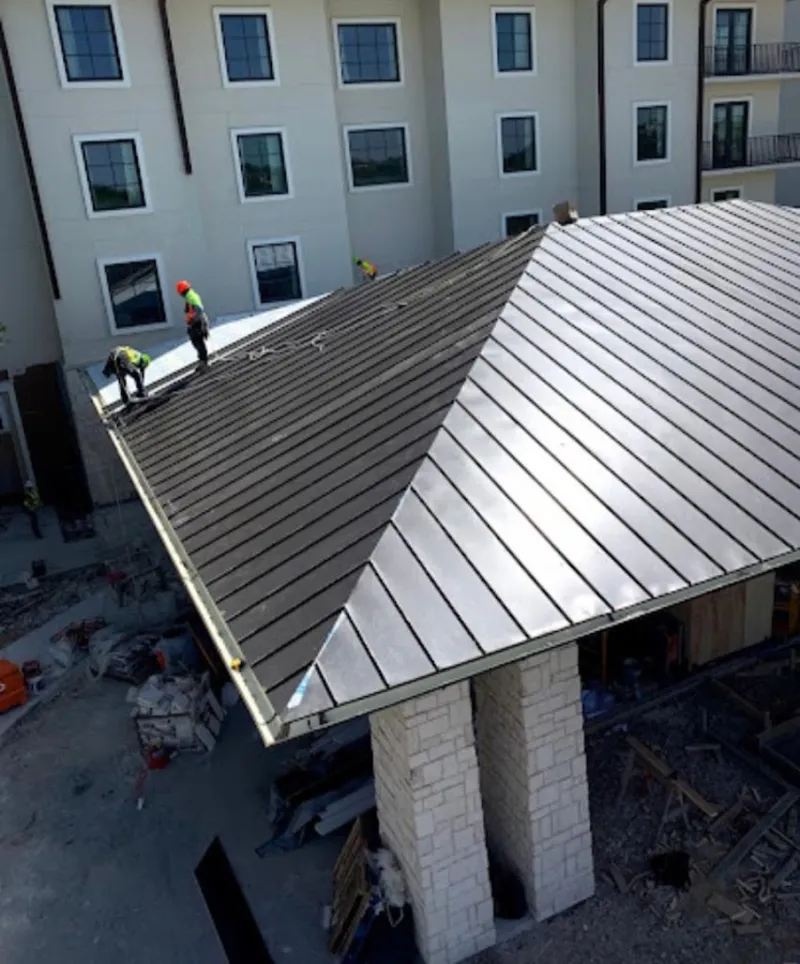 Crew installing standing seam metal roof panels on a commercial project in Harker Heights